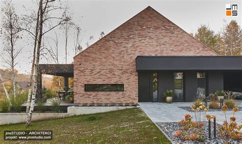 Nowoczesny budynek z czarnymi parapetami granitowymi i antracytową stolarką okienną