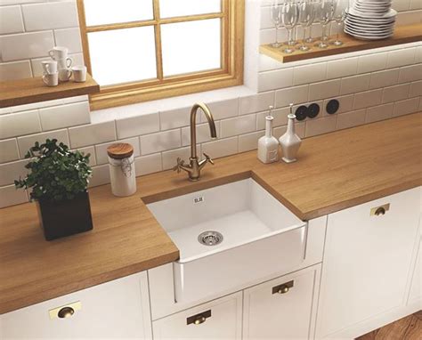 Stylowy, biały ceramiczny zlewozmywak z widocznym frontem w rustykalnej kuchni