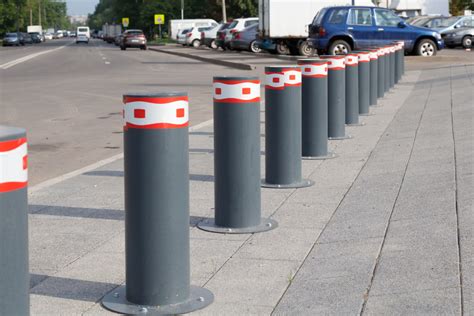 Ilustracja betonowych słupków parkingowych na miejskim parkingu