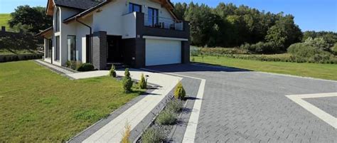 Wąski podjazd z zieloną rabatą po jednej stronie